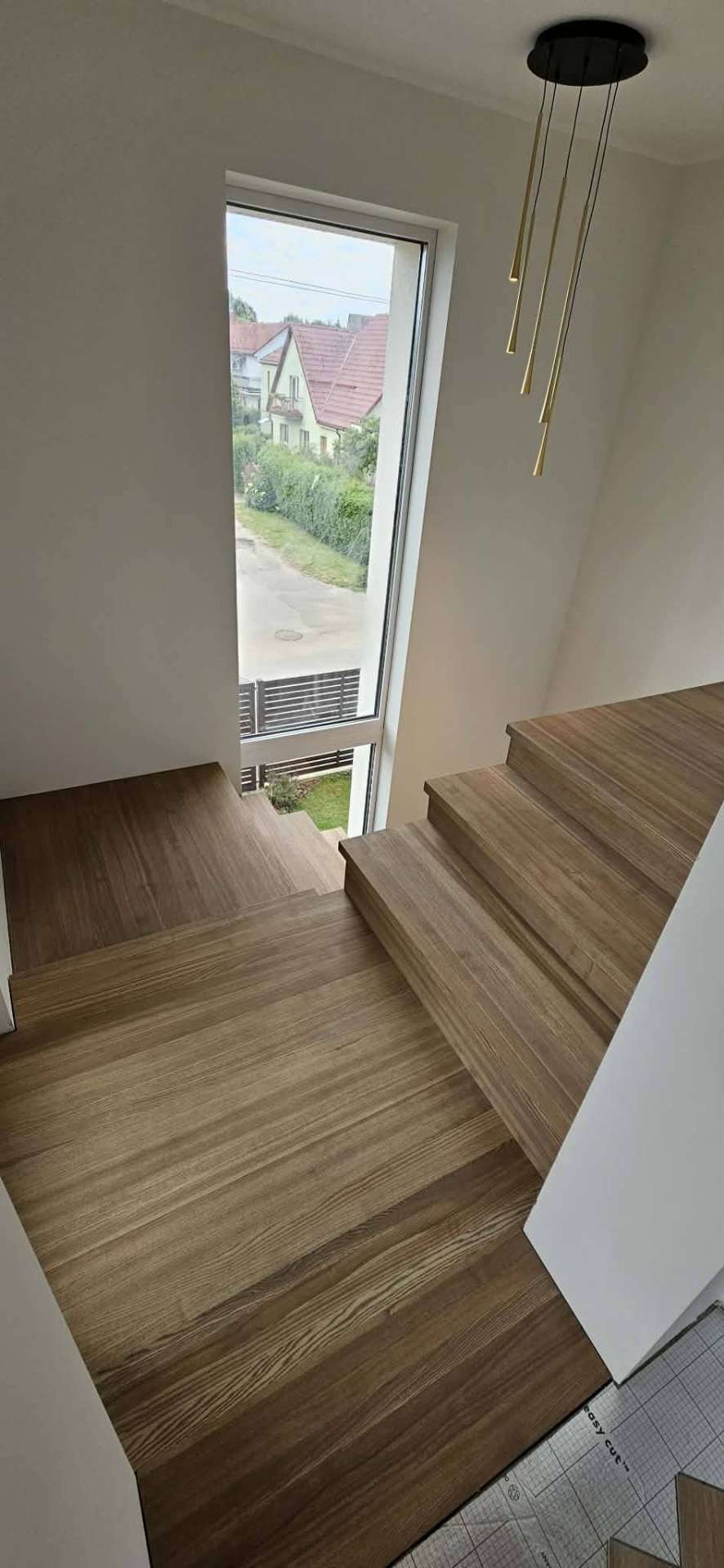 Šviesaus ąžuolo pakopos su tarpiniu poilsio aikštele prie lango